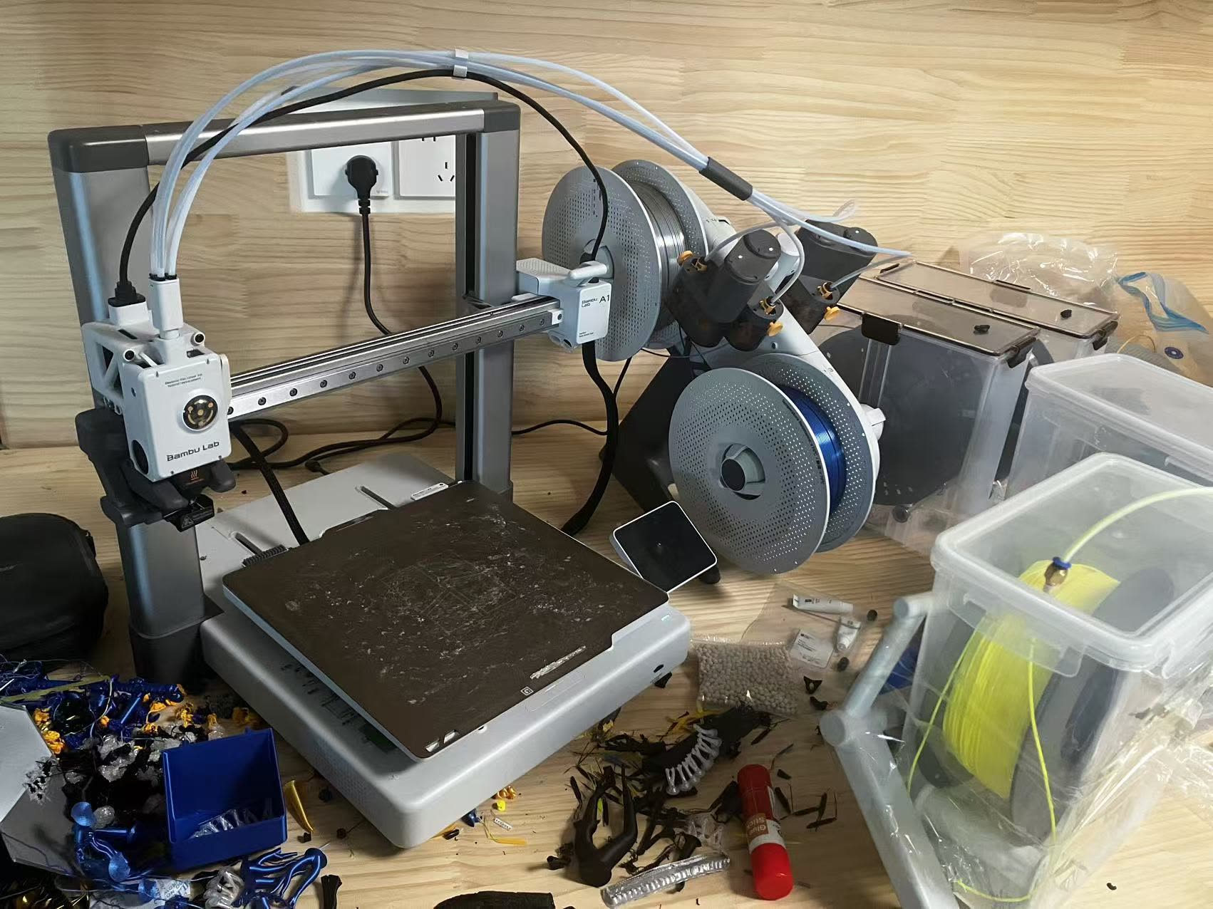Bambu Lab 3D printer on a workbench with printed parts